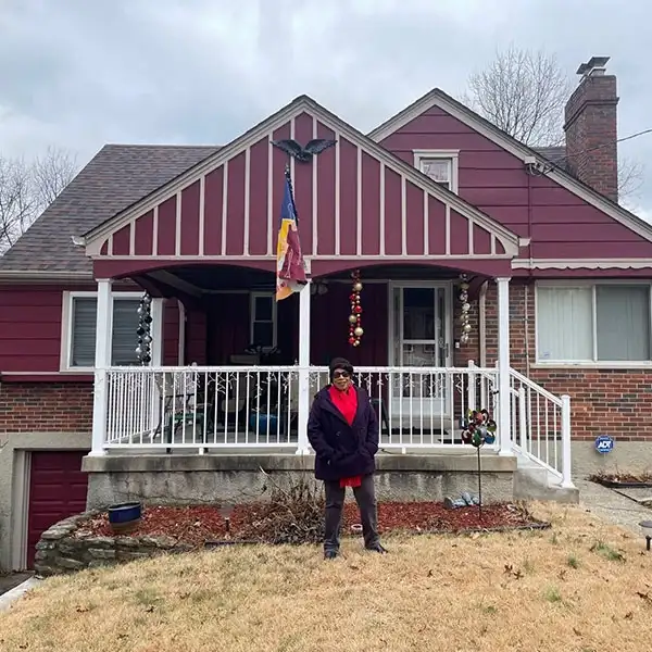Pat West stands proudly in front of her home after much needed improvements were made thanks to a forgivable home repair loan from Stockyards Bank & Trust.