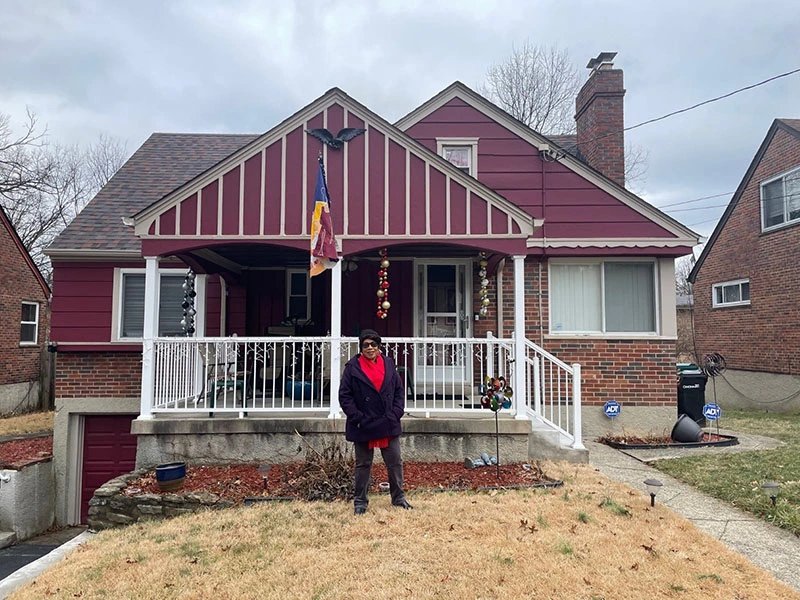 Pat West stands proudly in front of her home after much needed improvements were made thanks to a forgivable home repair loan from Stockyards Bank & Trust.