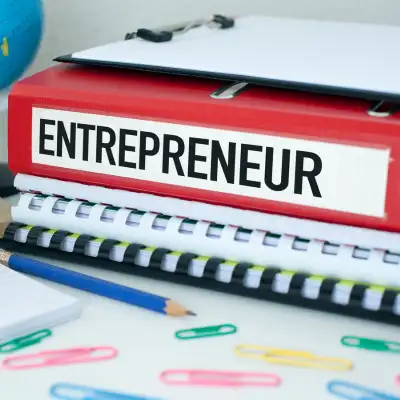 Pencils and paper on a desk, plus a stack of folders, one labeled "Entrepreneurship"