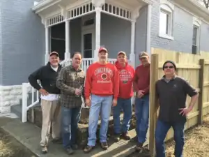A group of volunteers called the Old Timers stands in front of a home on Cedar Avenue after a long days work in 2023.
