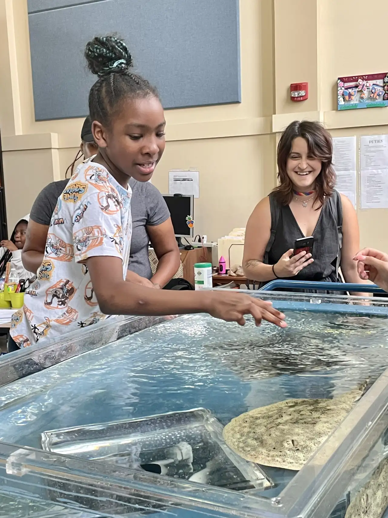 A young girl pets a stingray at WIN's 2023 Bringing the World to Our Backyard Summer Camp.