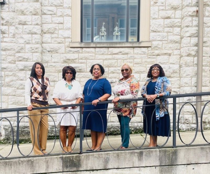 The five members of WIN's housing team pose outside celebrating Housing Counselor Day.