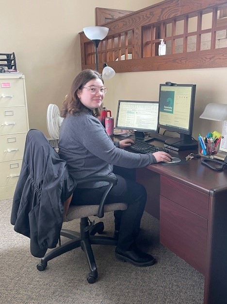 Leila Stacey, WIN's Fund Development and Marketing Assistant, sits working at her desk.